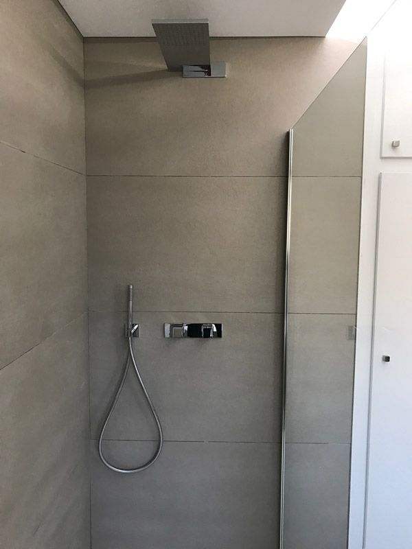 Une salle de bain avec une pomme de douche suspendue au plafond
