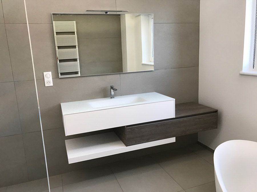 Une salle de bain avec lavabo, miroir et baignoire.