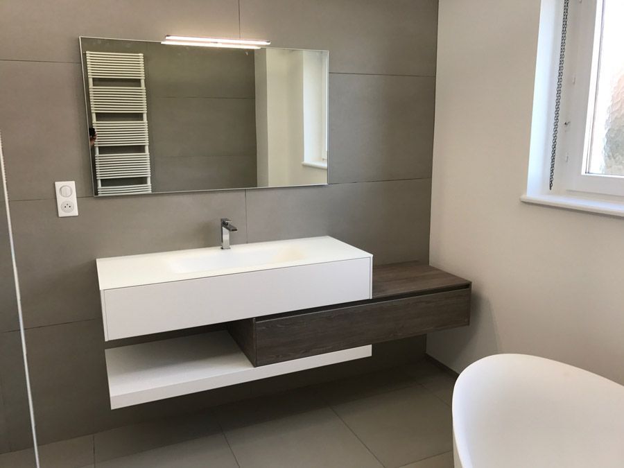 Une salle de bain avec lavabo, miroir et baignoire.