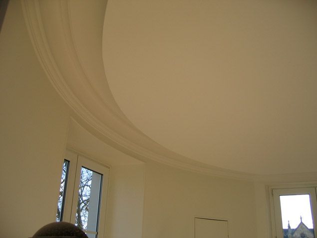 Une pièce blanche avec un plafond incurvé et des fenêtres