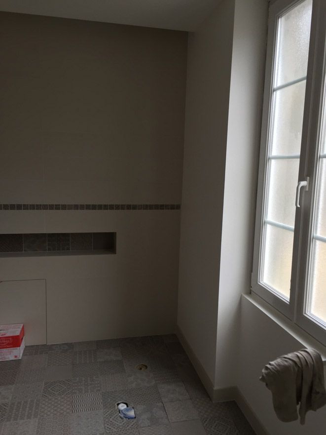 Une pièce vide avec une fenêtre et une serviette accrochée au mur.