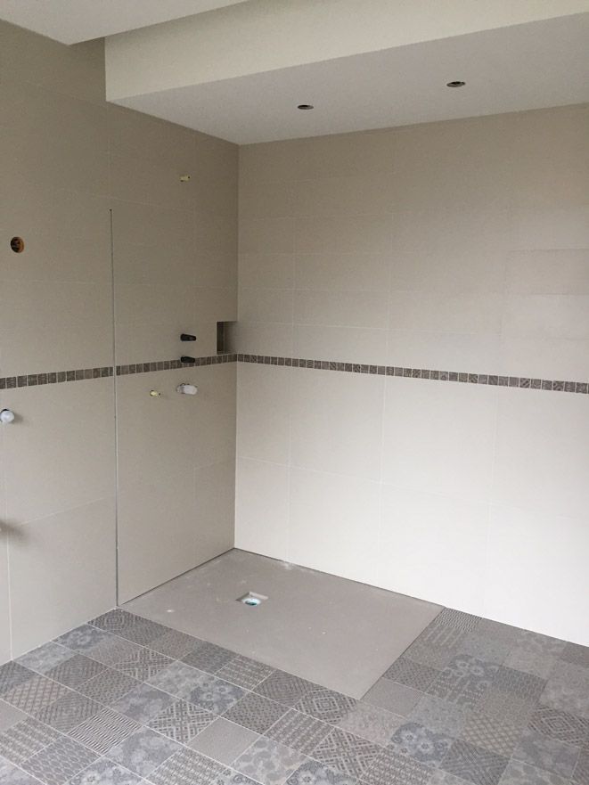 Une salle de bain avec douche à l'italienne et sol carrelé.