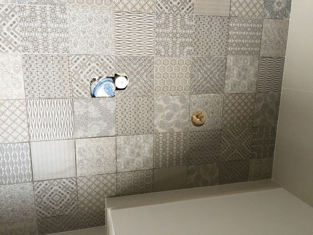 Une salle de bain avec un mur carrelé et un WC.