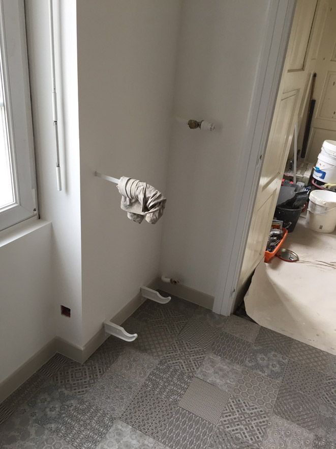 Une serpillière est accrochée au mur à côté d'une fenêtre dans une pièce.