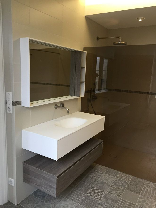 Une salle de bain avec un lavabo et un miroir au mur.