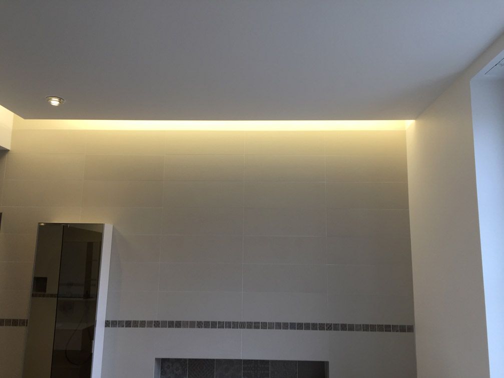 Une pièce avec des murs blancs et une lumière au plafond