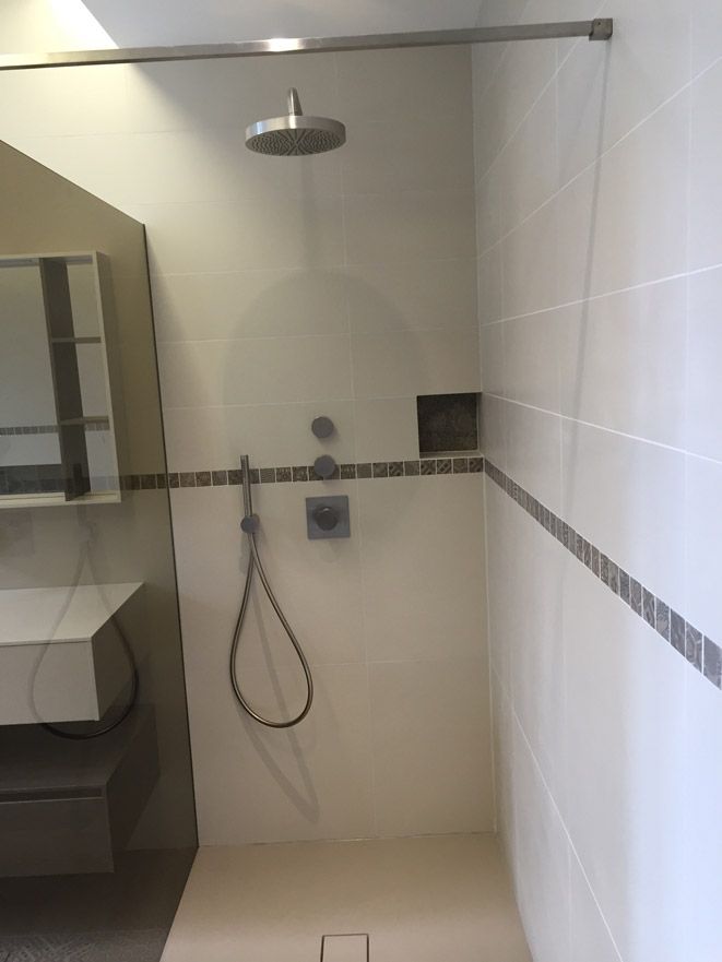 Une salle de bain avec une douche à l'italienne et un lavabo.