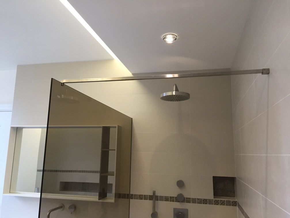 Une salle de bain avec une pomme de douche et un miroir