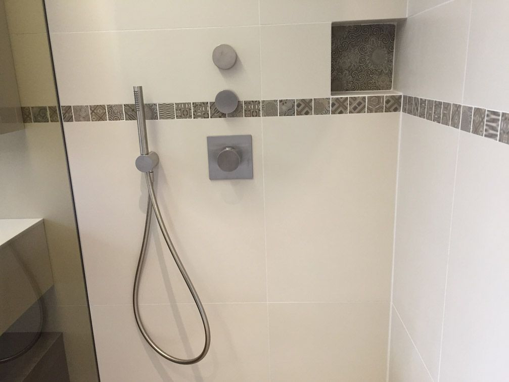 Une douche avec un tuyau fixé au mur.