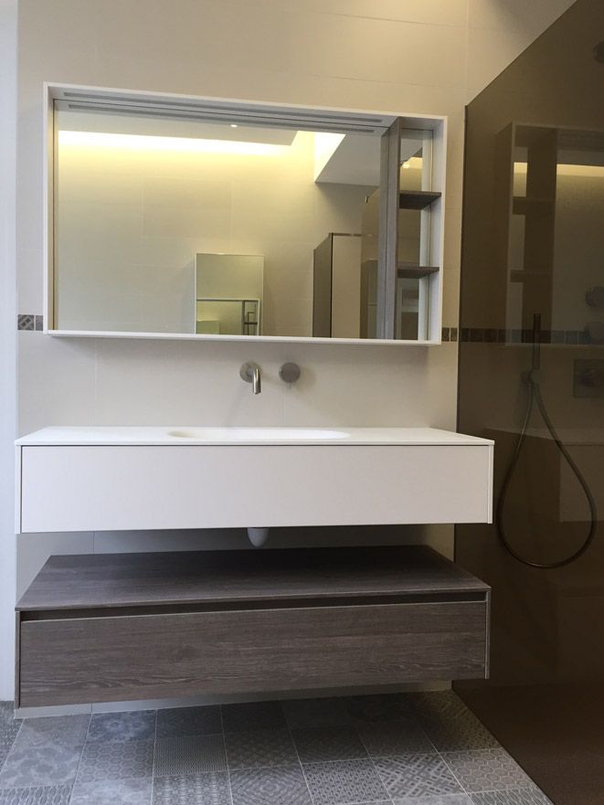 Une salle de bain avec un lavabo et un grand miroir
