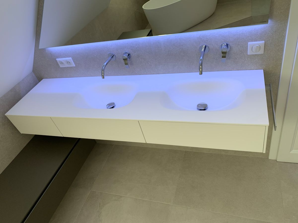 Une salle de bain avec deux lavabos et un miroir