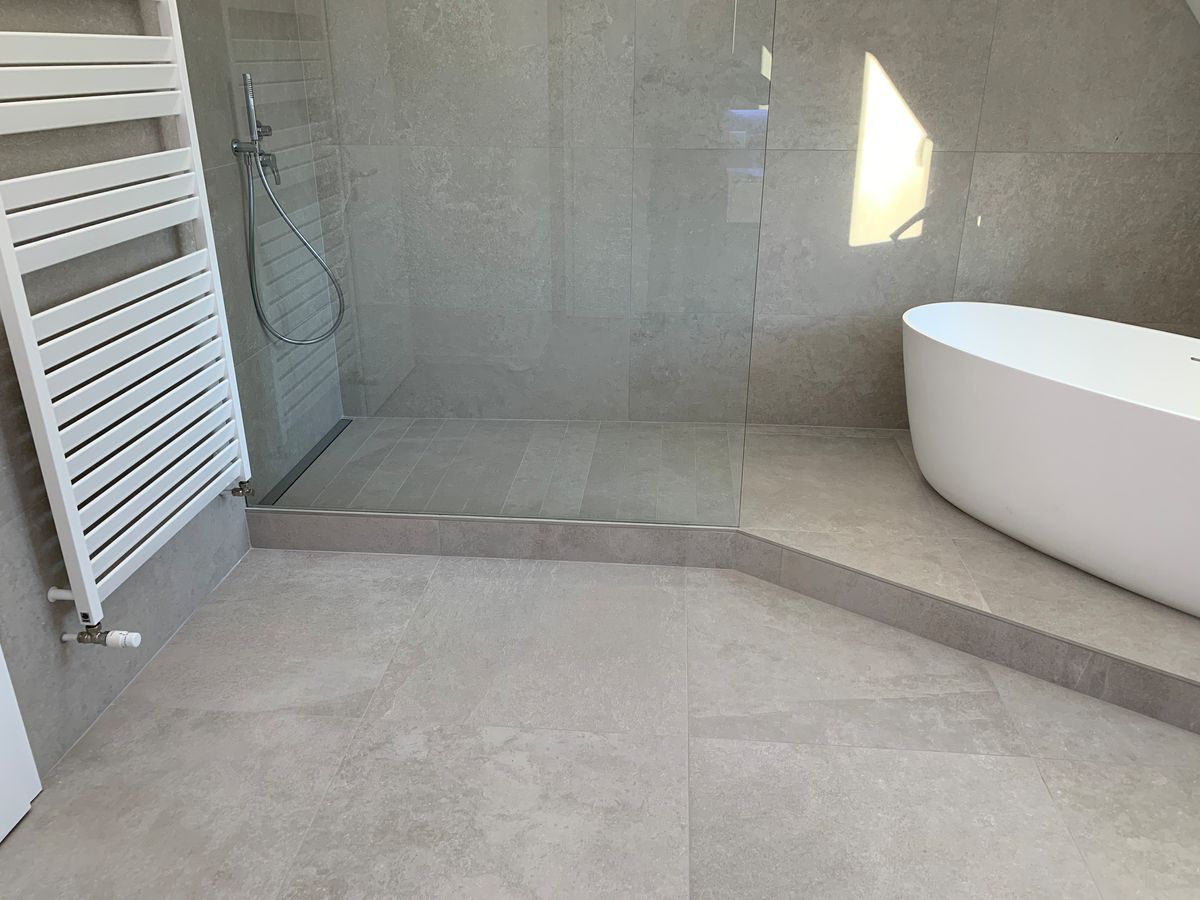 Une salle de bain avec baignoire, douche et porte-serviettes.