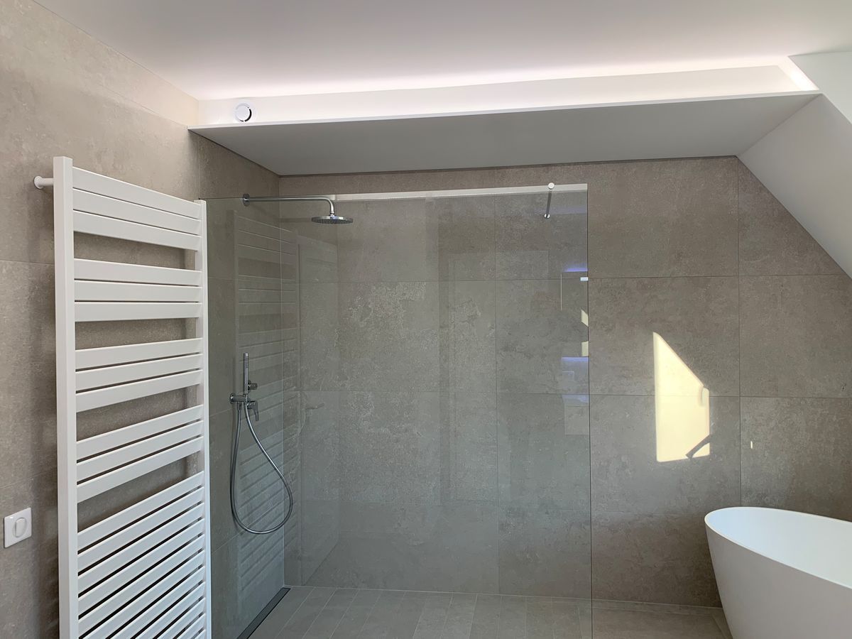 Une salle de bain avec douche à l'italienne et baignoire.