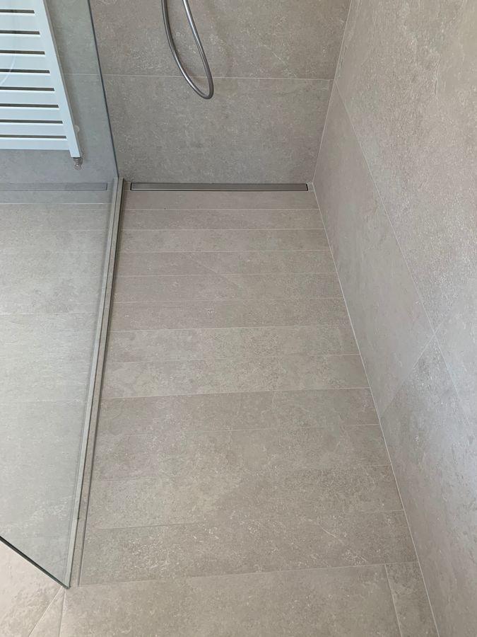 Une salle de bain avec douche à l'italienne et sèche-serviettes.