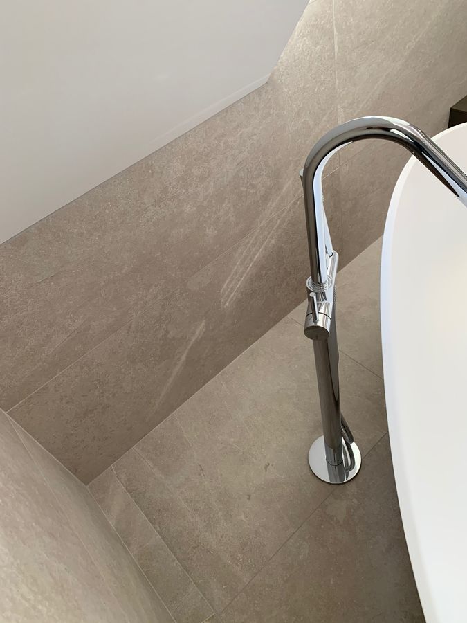 Un lavabo de salle de bain avec un robinet chromé au sol