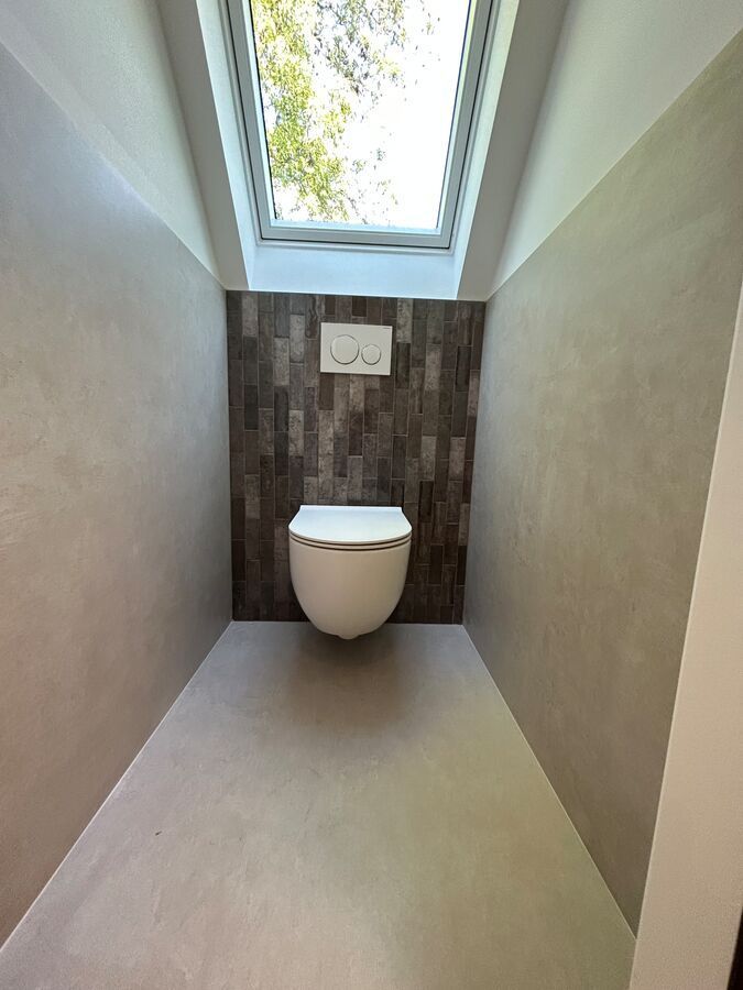 Une salle de bain avec WC et un puits de lumière.