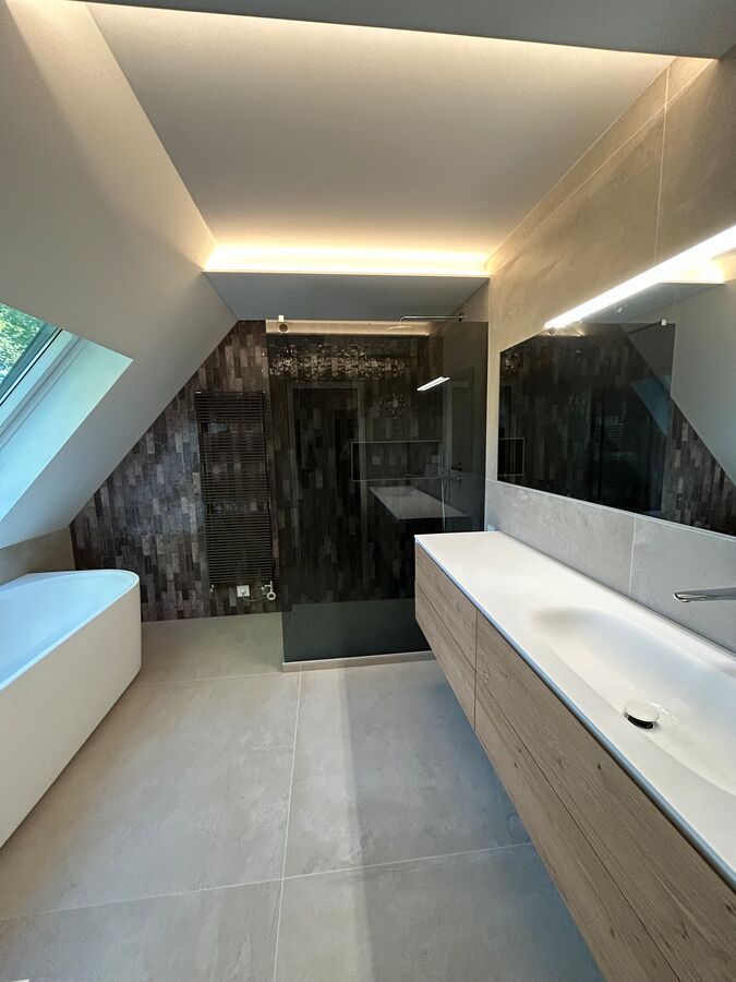 Une salle de bain avec baignoire, lavabo et miroir