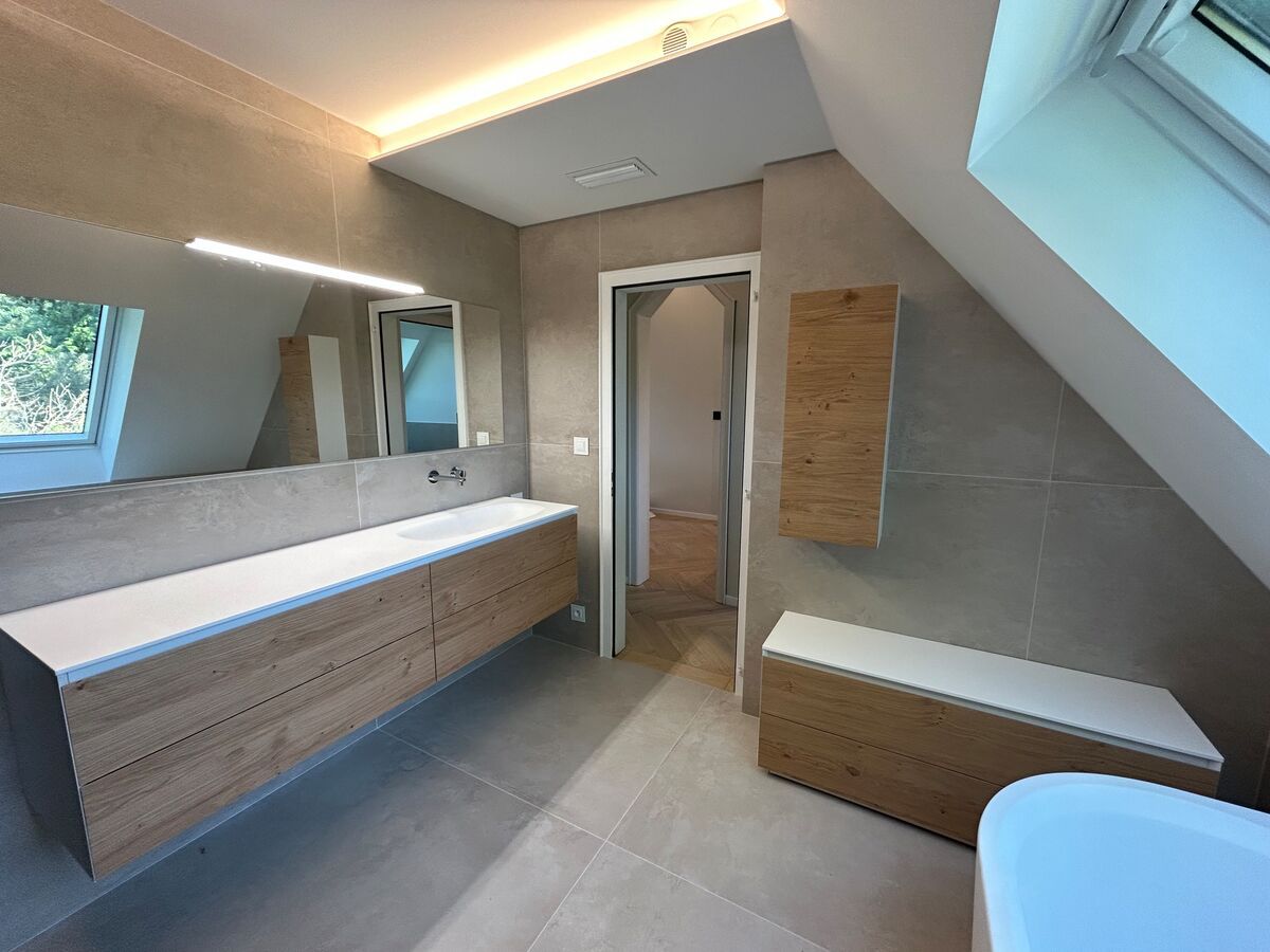 Une salle de bain avec deux lavabos, deux miroirs et une baignoire.