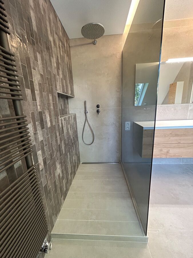 Une salle de bain avec douche à l'italienne et sèche-serviettes.