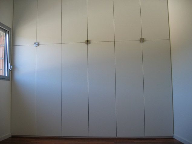 Une pièce vide avec des armoires blanches et une fenêtre