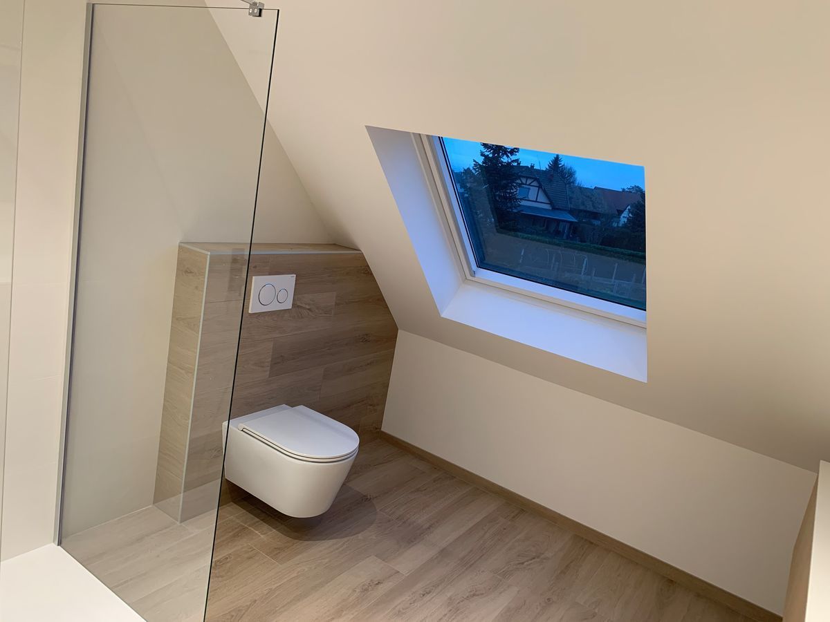 Une salle de bain avec WC et une fenêtre.