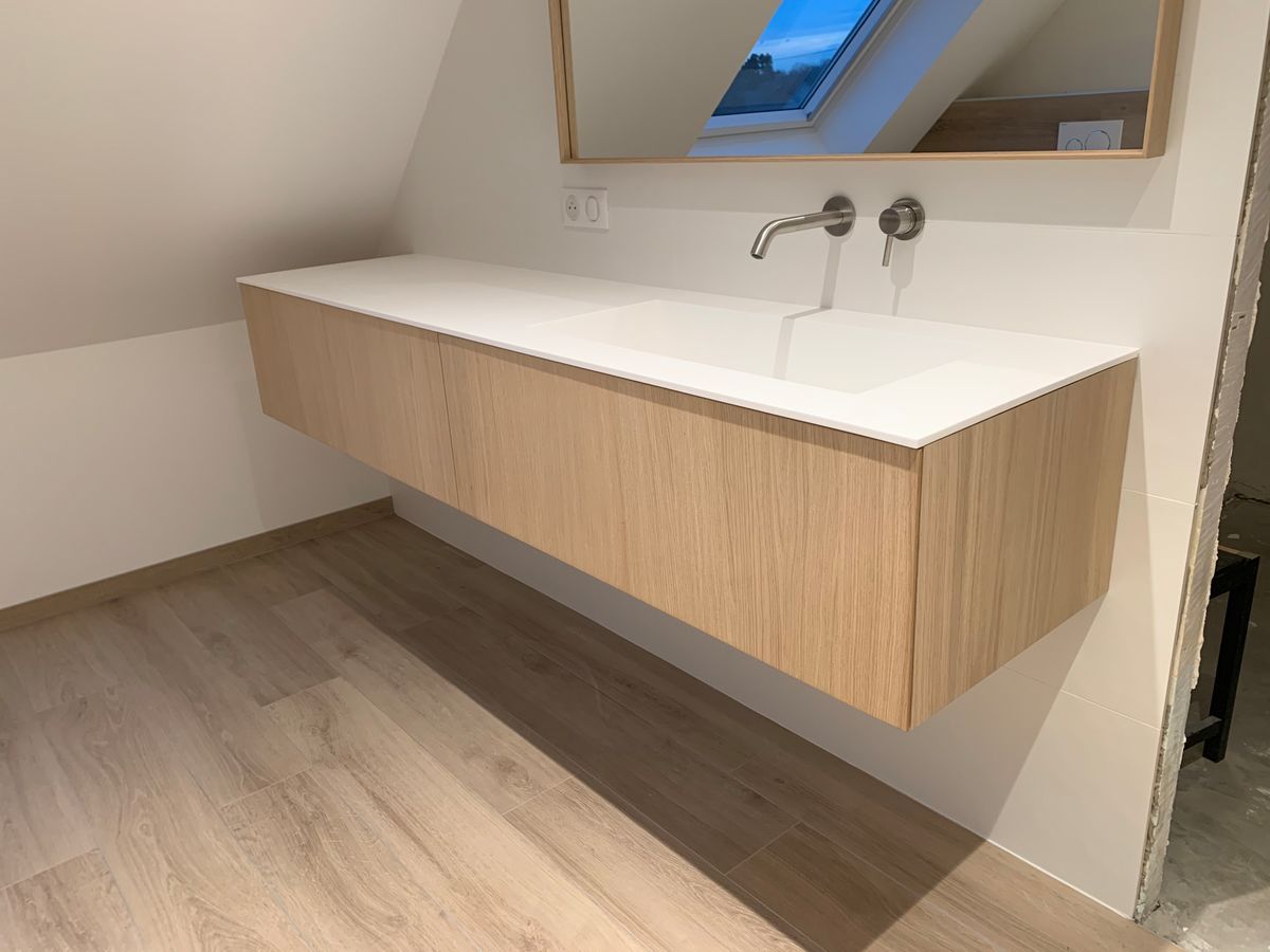 Une salle de bain avec un lavabo et un miroir au mur.