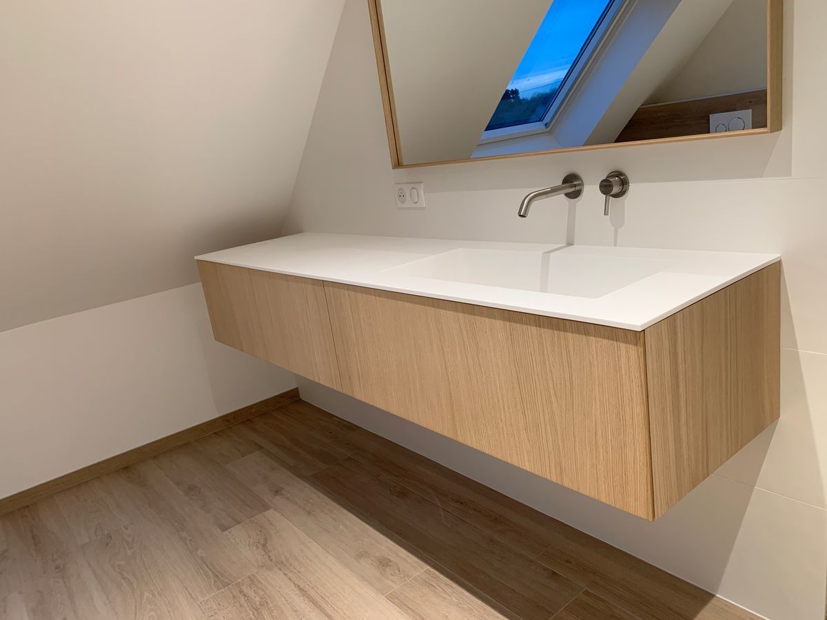 Une salle de bain avec un lavabo et un miroir au mur.