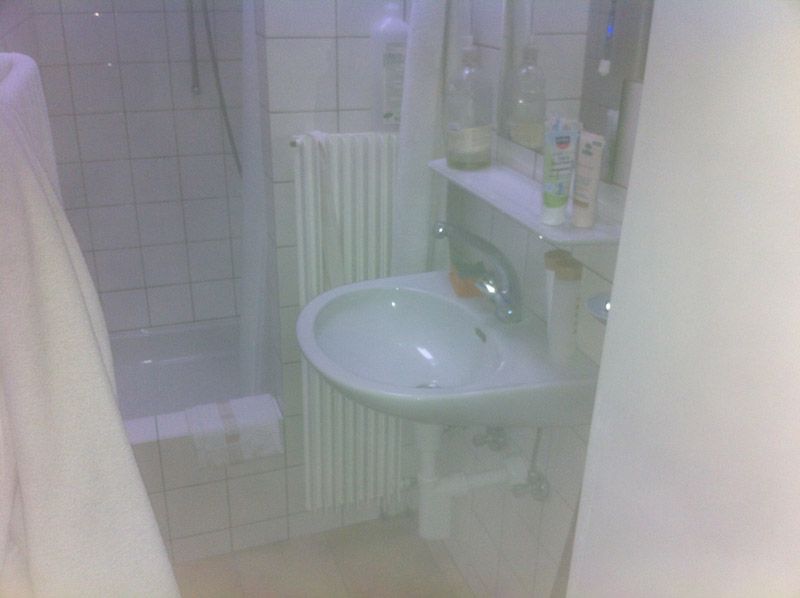 Une salle de bain avec lavabo, douche et miroir.