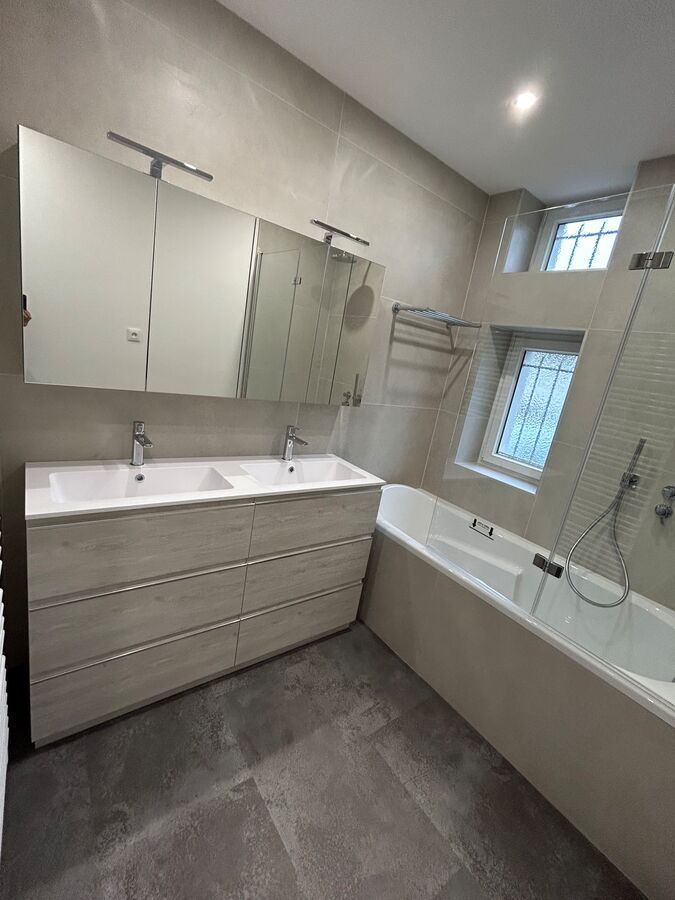 Une salle de bain avec deux lavabos et une baignoire.