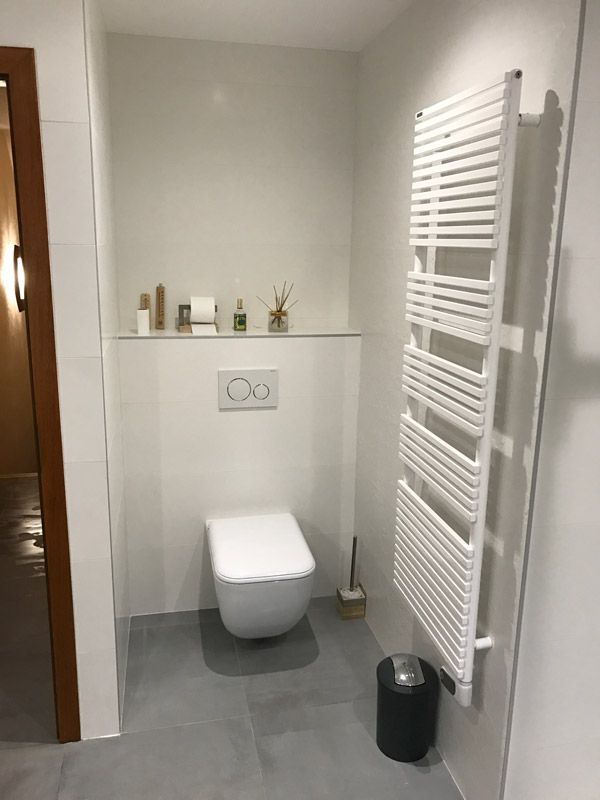 Une salle de bain avec WC et sèche-serviettes.