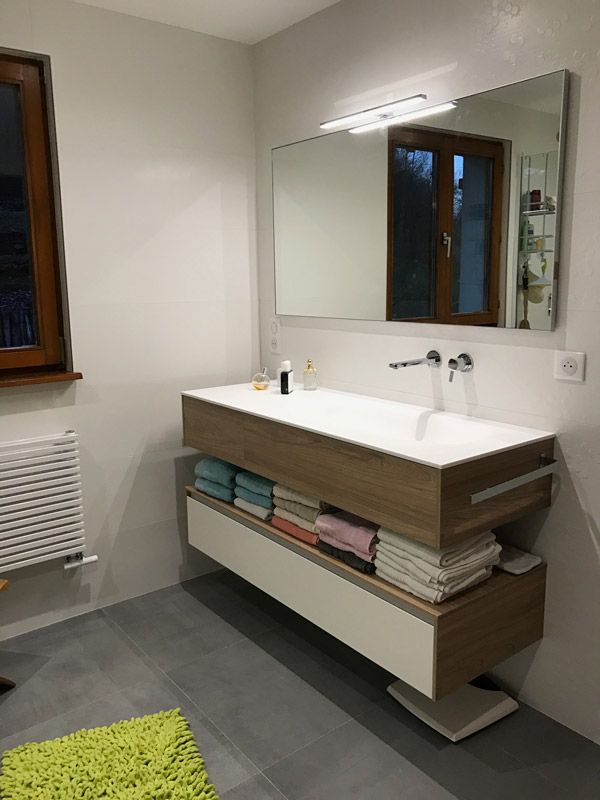 Une salle de bain avec un lavabo et un grand miroir