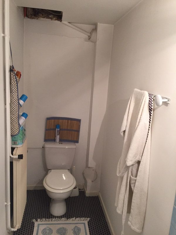 Une salle de bain avec toilettes et porte-serviettes