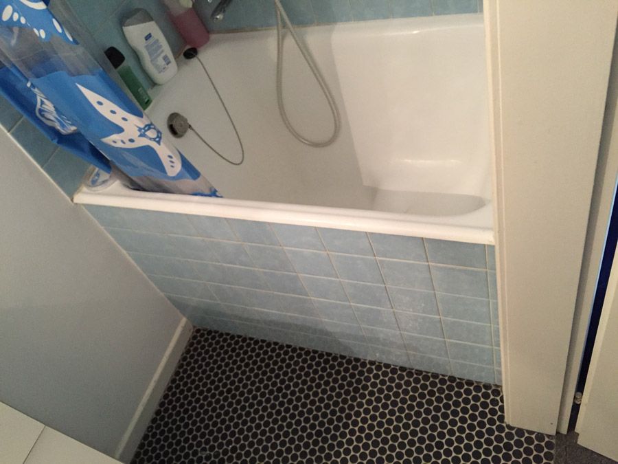 Une baignoire dans une salle de bain avec un rideau de douche bleu