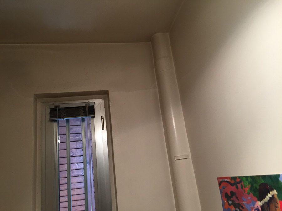 Une pièce avec une fenêtre et un tableau sur le mur.