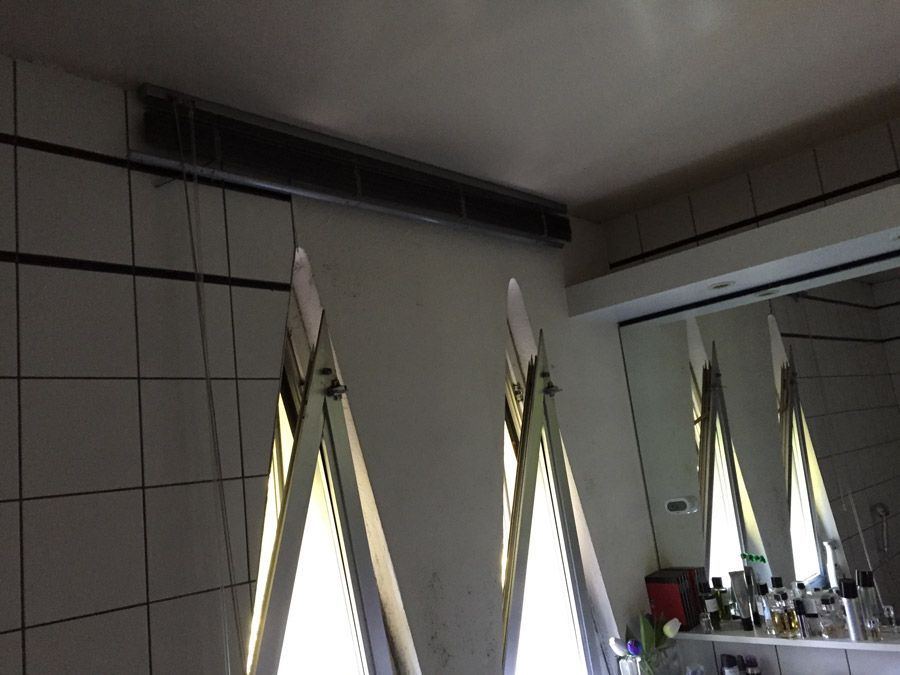 Une salle de bain avec beaucoup de fenêtres et un miroir