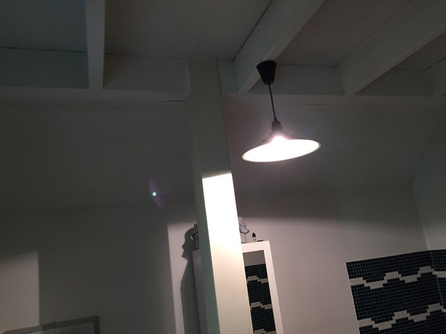 Une lumière suspendue au plafond dans une pièce sombre