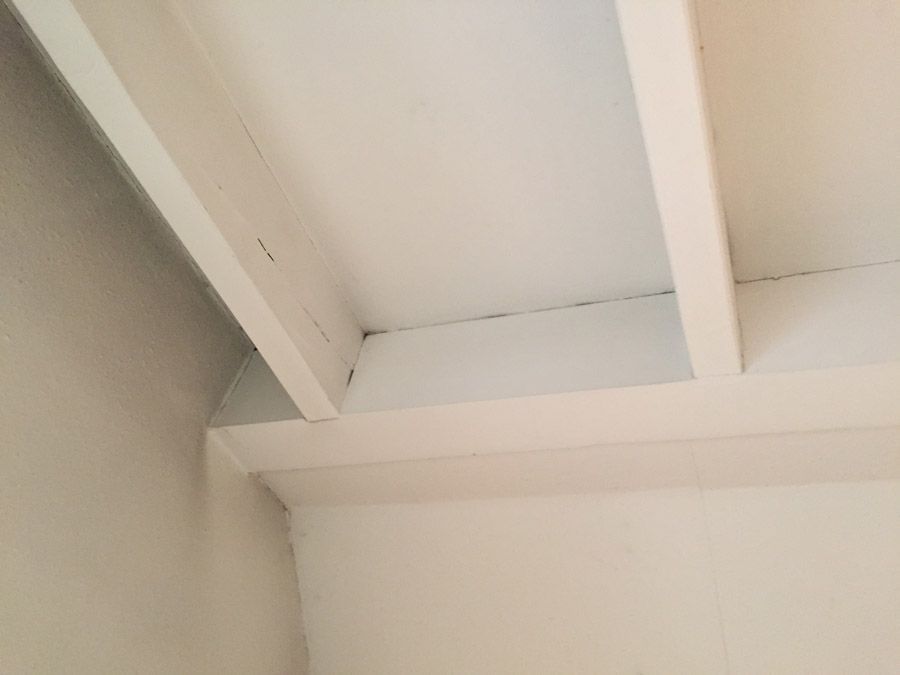 Un gros plan d'un plafond blanc avec des poutres en bois.