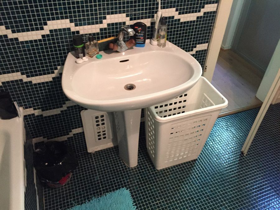 Une salle de bain avec un lavabo et un panier à linge