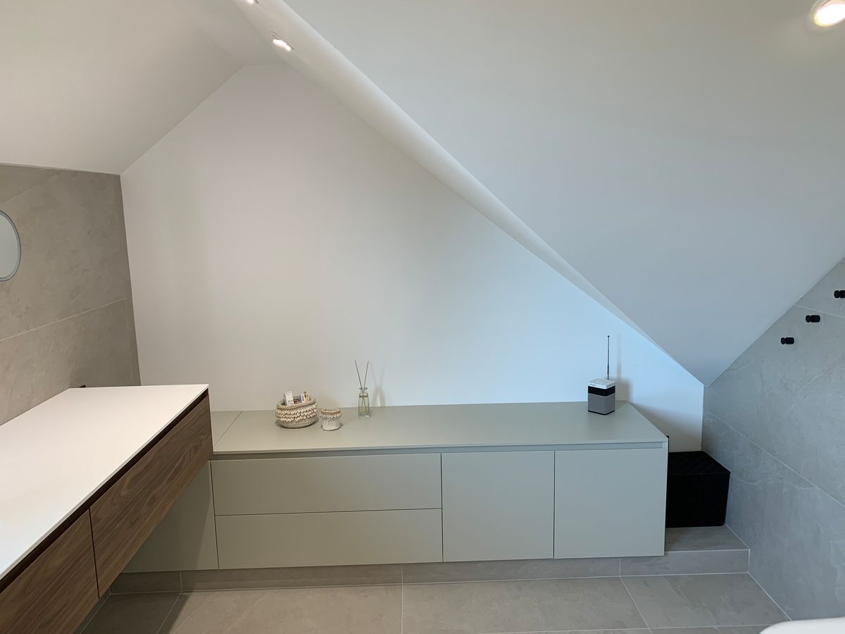 Une salle de bain avec un plafond mansardé et un lavabo