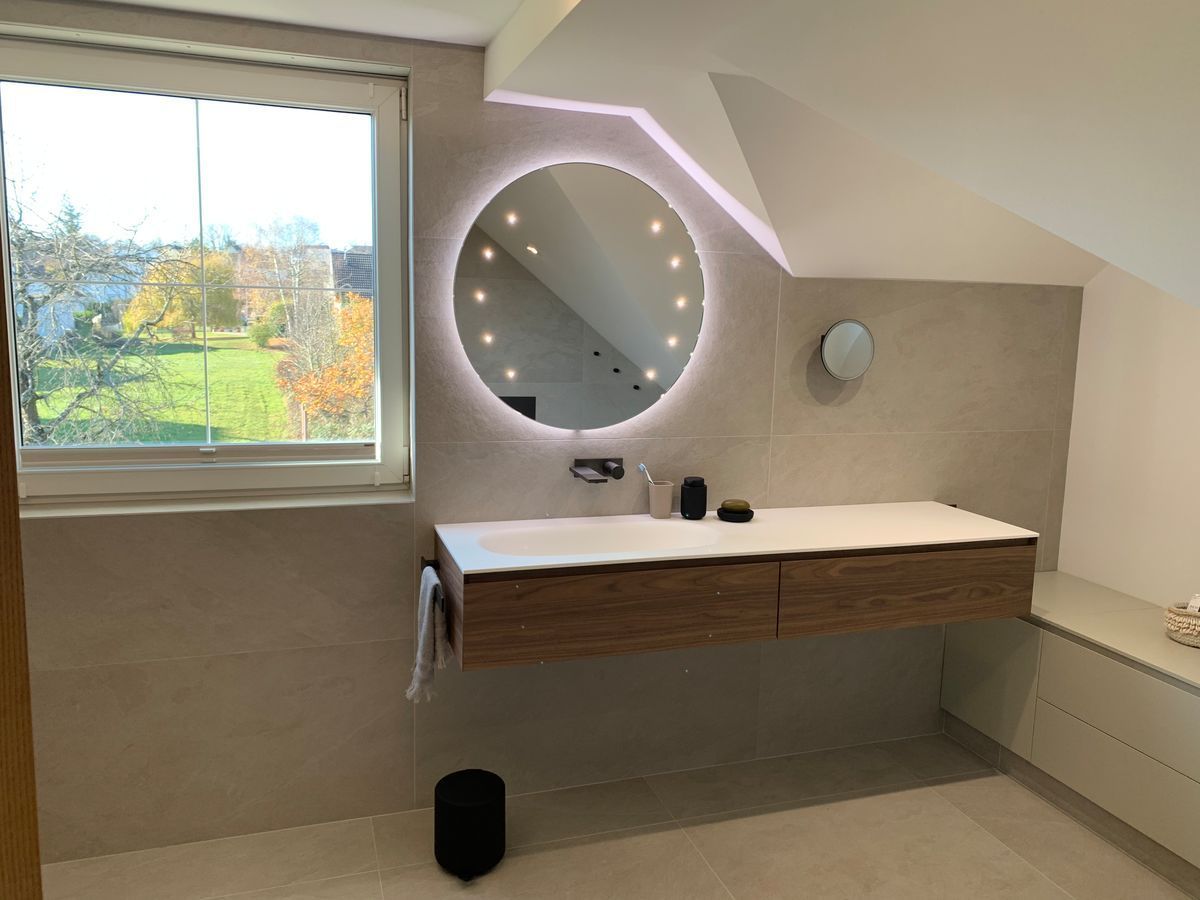 Une salle de bain avec un lavabo, un miroir et une fenêtre.