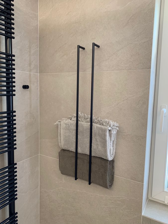 Deux serviettes sont accrochées à un porte-serviettes dans une salle de bain.