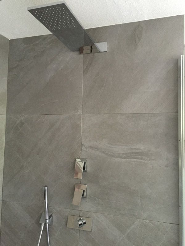 Une pomme de douche est suspendue au plafond dans une salle de bain.