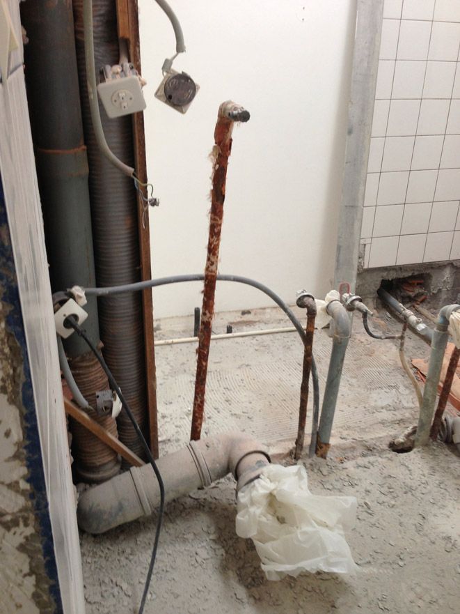 Une salle de bain avec beaucoup de tuyaux et de fils