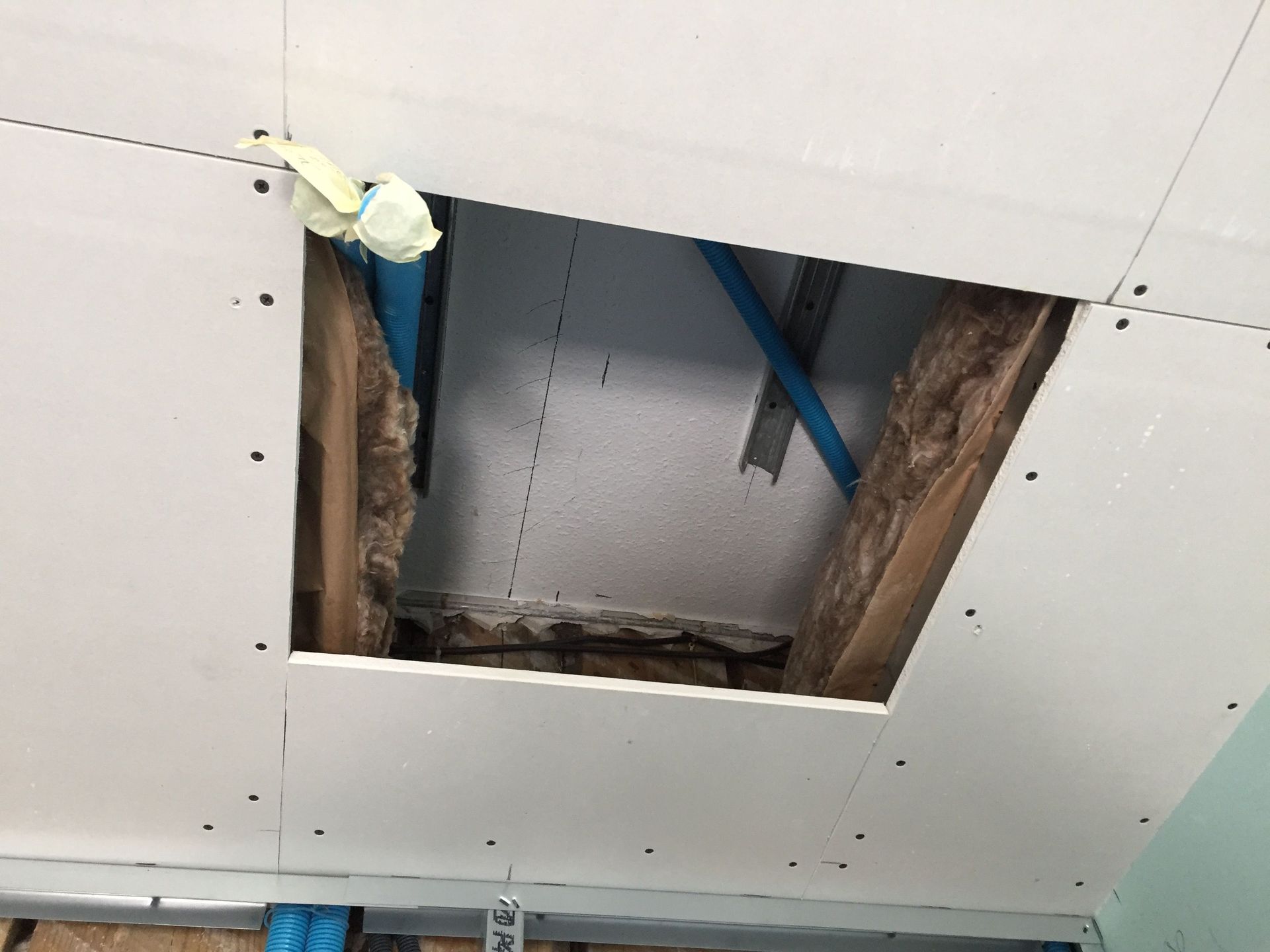 Un trou dans le plafond avec des tuyaux qui en sortent.