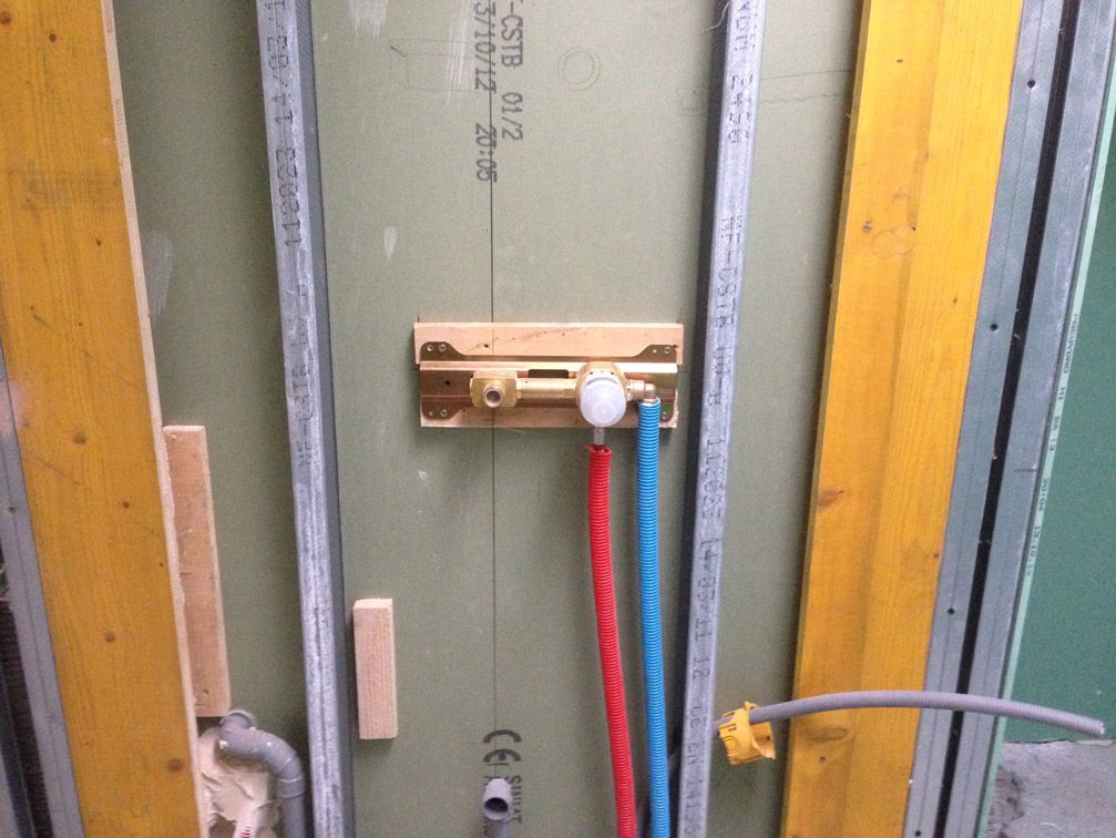 Un mur avec un tas de tuyaux qui en sortent