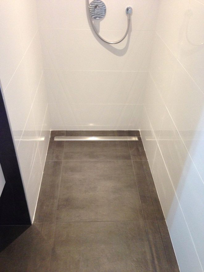 Une salle de bain avec douche et sol carrelé.