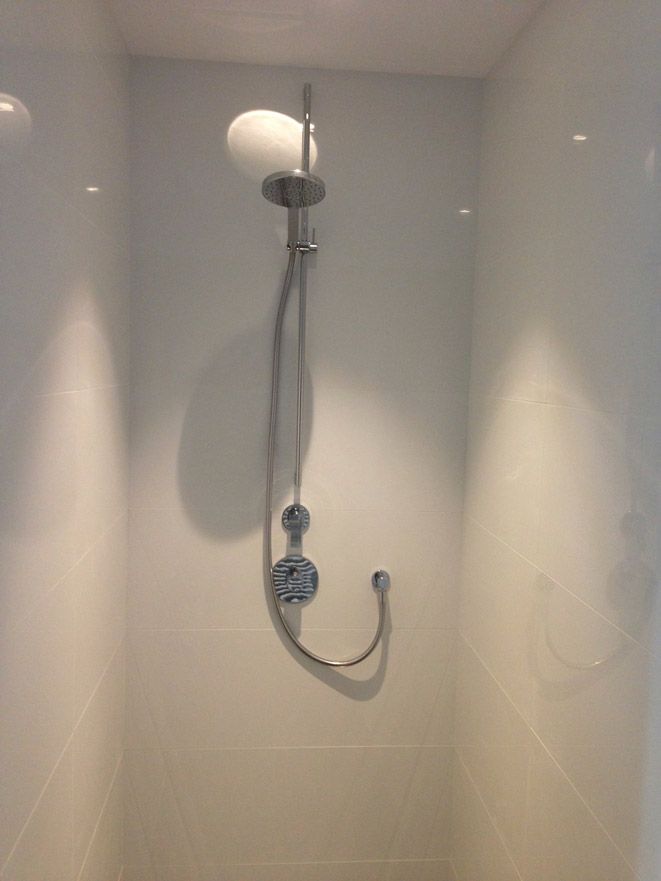 Une pomme de douche est suspendue au plafond dans une salle de bain.