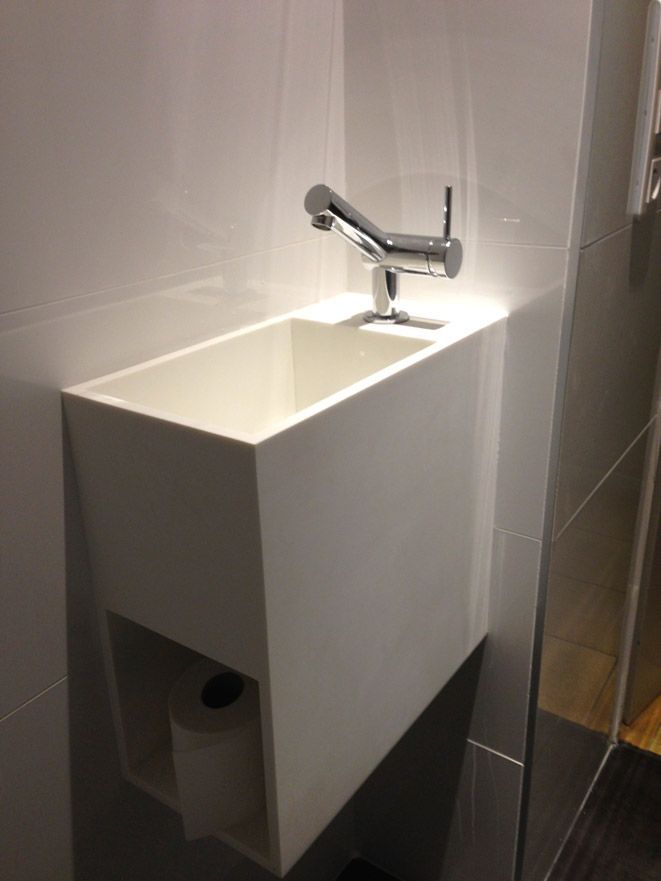 Un lavabo de salle de bain avec un porte-papier toilette en dessous