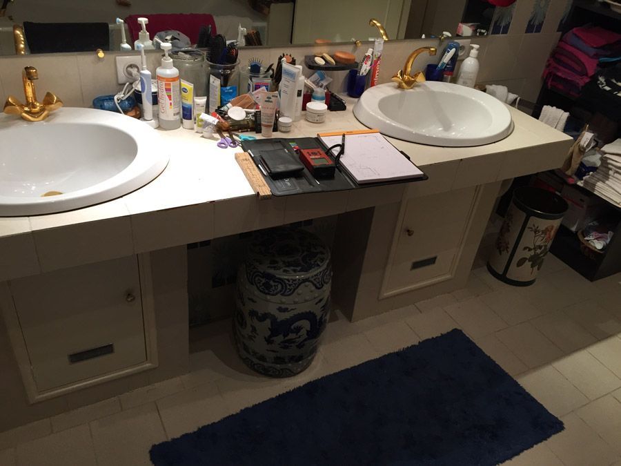 Une salle de bain avec deux lavabos et un tapis bleu