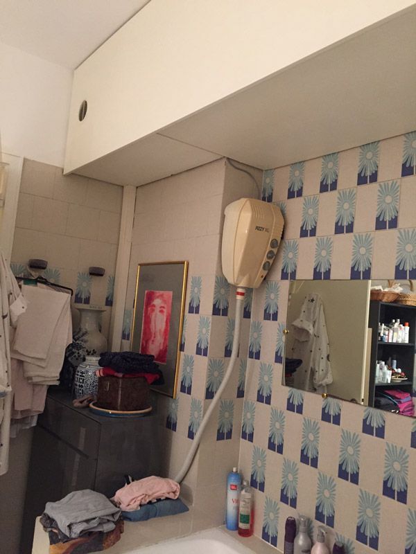 Une salle de bain avec un lavabo, un miroir et un sèche-cheveux